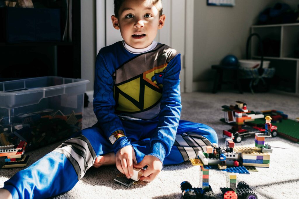 A boy builds with legos during a documentary family photography session by These Days Photography in Fairfax, VA
