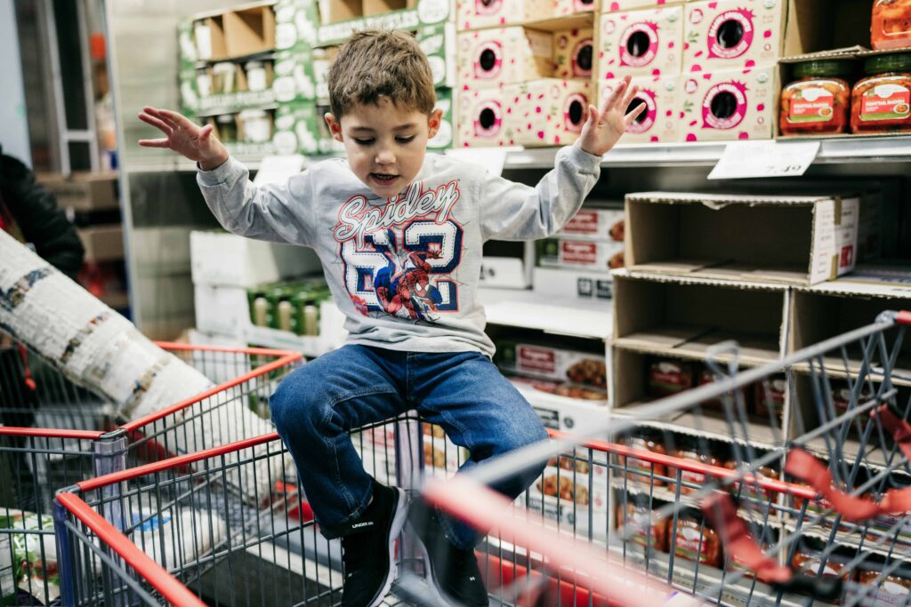 A boy sits in a shopping cart during a trip to COSTCO during a documentary family photography session by These Days Photography in Fairfax, VA
