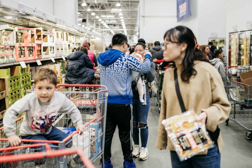 A boy sits in a shopping cart during a trip to COSTCO during a documentary family photography session by These Days Photography in Fairfax, VA