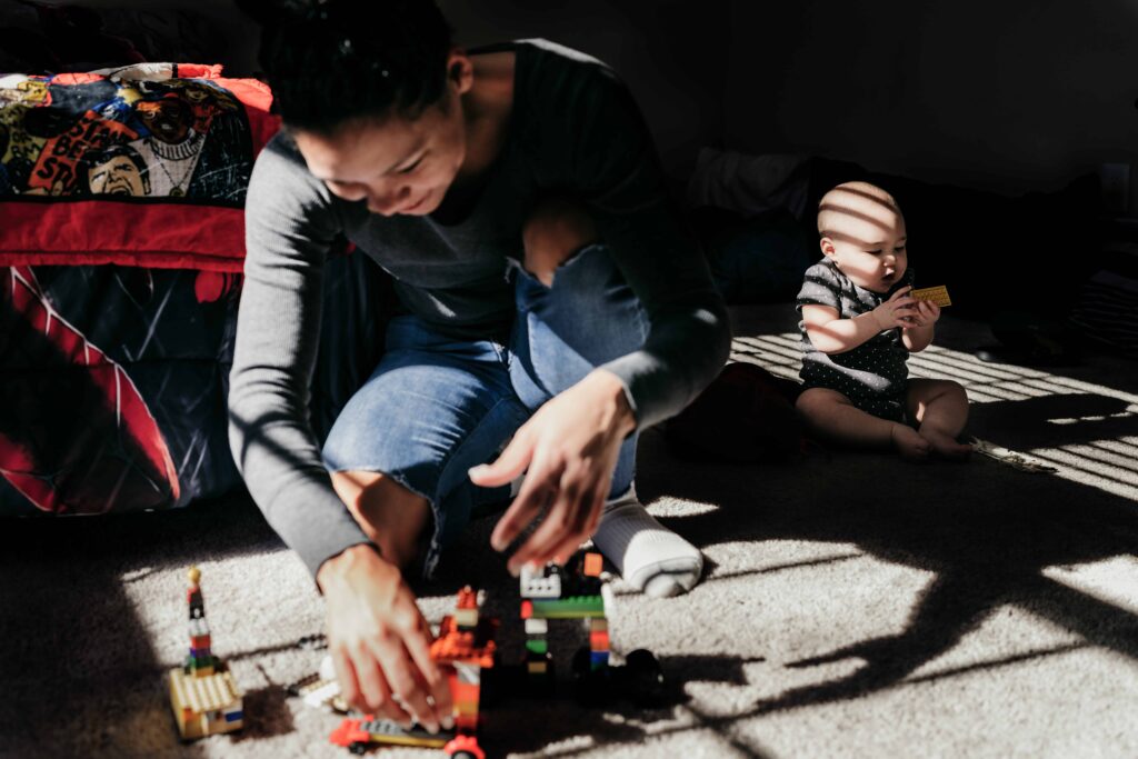 A mom builds legos in her son's room during a documentary family photography session by These Days Photography in Fairfax, VA